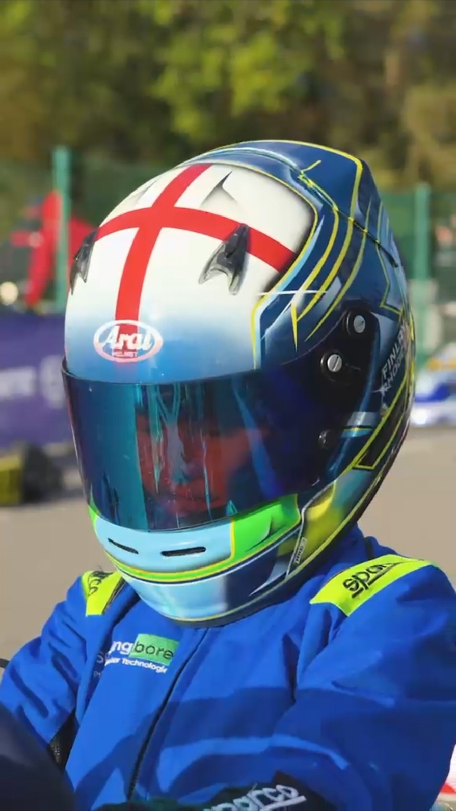 Finlay Rhodes in his blue and lime race suit and England-cross helmet